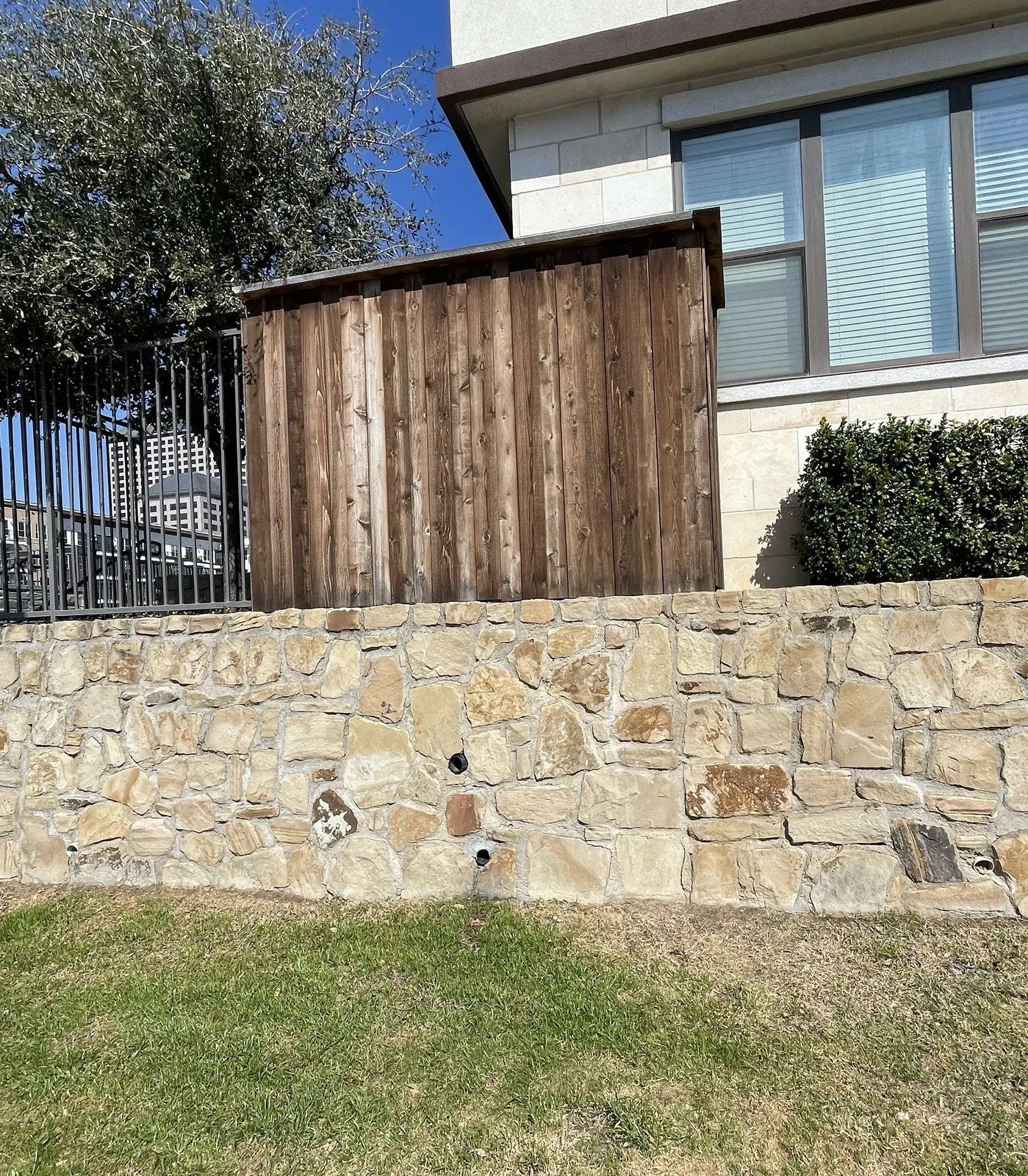 Stone retaining wall with wood fence above