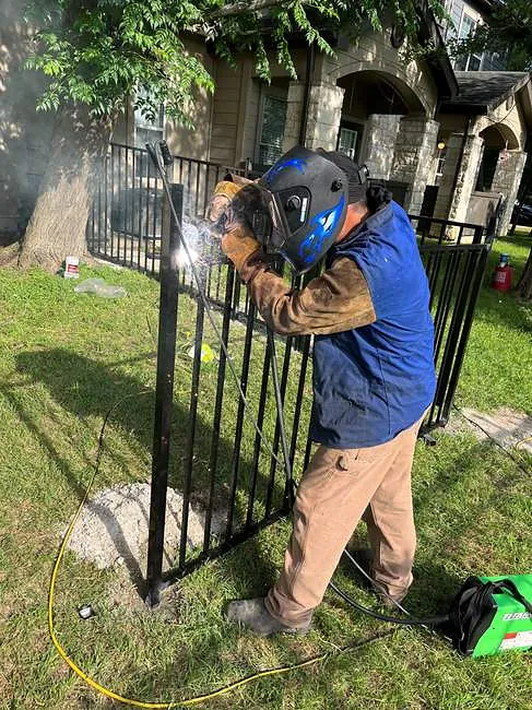 Welder on iron fence